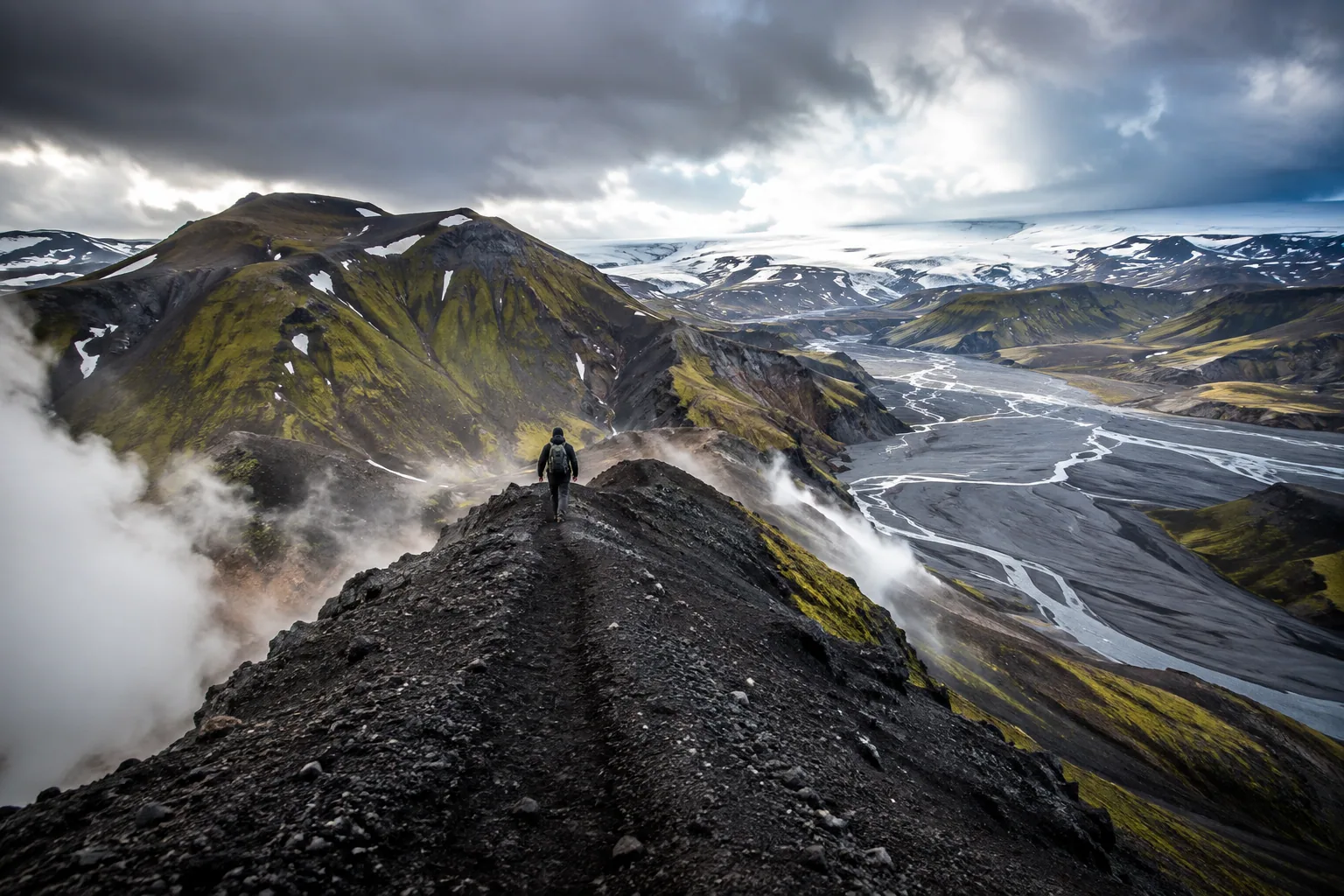 Hiker crossing a mossy Icelandic mountain trail beside a glacial river