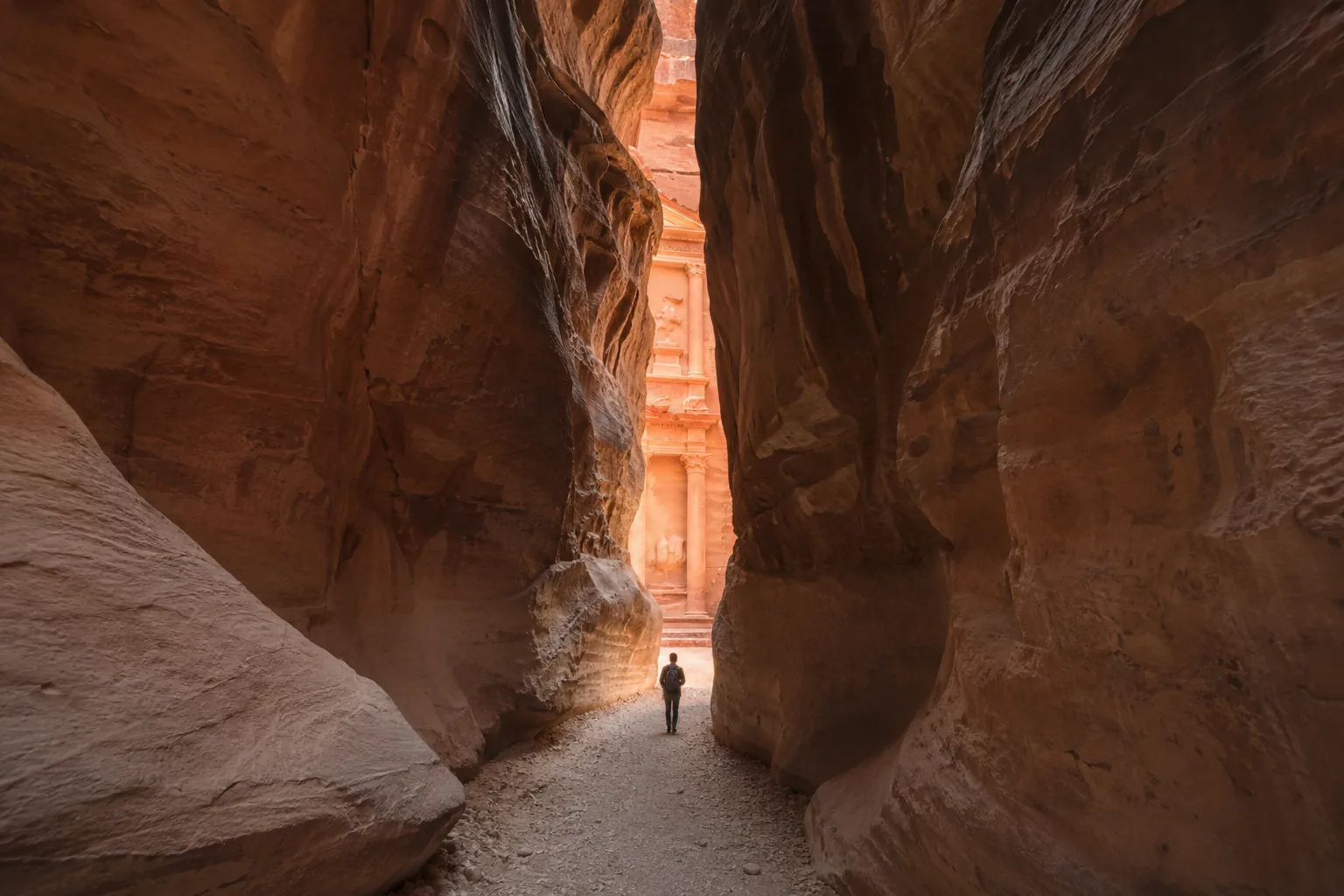 Traveller walking through the Siq toward the Treasury at first light